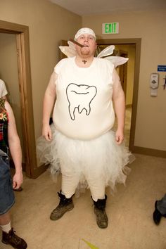 a man dressed as tooth fairy standing next to a woman