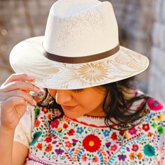 These unique and stylish artisanal hats were hand painted by Alicia in Oaxaca, Mexico. Each hat displays vibrant and fun designs that take hours to create and so versatile you can wear year-round. Our unique, curated design selections offer a modern touch to the traditional Mexican designs and will complement many fashion styles. Size: Medium 22.8 inches. One size fit most; hat features an internal elastic band for comfort. Materials: Painted jute. The hat brim features a leather band and colors White Artisan Hat For Kentucky Derby, Artisan White Hat For Kentucky Derby, White Toquilla Straw Panama Hat For Festivals, Artisan White Fedora Straw Hat, Artisan Hand Painted Brimmed Sun Hat, White Artisan Straw Hat With Short Brim, Bohemian Hand Painted Panama Hat With Flat Brim, White Artisan Hat With Short Brim, Artisan Panama Hat In Toquilla Straw For Festivals