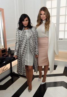 two women standing next to each other in front of a mirror