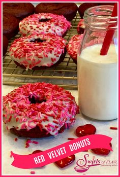 red velvet donuts with white frosting and sprinkles on a cooling rack