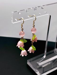 Discover elegance with these handmade 18k Gold Plated Pink Lily of the Valley Dangle Earrings. Featuring vibrant cats eye acrylic beads and dainty flower charms, these delicate pink-themed earrings are a perfect nature-inspired addition any outfit. Ideal for those seeking unique, effeminate jewelry that blends elegance with floral charm. DETAILS: > Dimensions: ~2.3in L x ~.5in W  > Earring Weight (pair): ~.14oz > 18K Gold Plated Stainless Steel Flat Earwire > Brass Findings, Fiber Optic Acrylic Delicate Dangle Earrings With Flower Charm, Delicate Pink Earrings, Adjustable Dangle Earrings With Flower Charm, Delicate Dangle Flower Earrings With Matching Set, Delicate Hypoallergenic Dangle Flower Earrings, Rose Gold Dangle Flower Earrings, Handmade Rose Gold Flower Dangle Earrings, Handmade Rose Gold Flower Drop Earrings, Delicate Pink Pierced Earrings