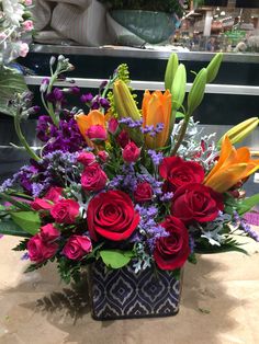 a vase filled with lots of different colored flowers