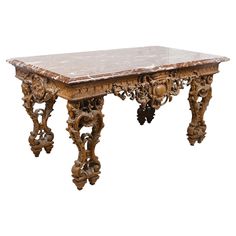 an ornately carved wooden table with marble top and legs, against a white background