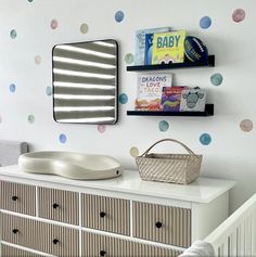 a baby's room with polka dot decals on the wall and a dresser