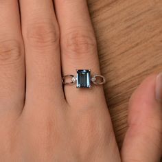 It is a London blue topaz ring. The main stone is 6 mm*8 mm emerald cut.weight about 2.01 carats. The basic metal is sterling silver and plated with rhodium. To change the metal to a solid gold (white/rose) or platinum is also available, please ask for a quotation if you want. You can also go to my shop Home for more elegant rings: https://www.etsy.com/shop/godjewelry?ref=hdr_shop_menu London blue topaz is November birthstone More London blue topaz rings: https://www.etsy.com/shop/godjewelry?ref Emerald Cut Topaz Ring In 14k White Gold, Classic Emerald-cut Topaz Ring In Sterling Silver, Fine Jewelry Topaz Promise Ring With Rectangular Stone, Fine Jewelry Topaz Ring With Rectangular Stone For Promise, Rectangular Topaz Ring For Anniversary, Classic Blue Topaz Emerald Cut Ring, Emerald-cut Topaz Ring In 14k White Gold, Emerald Cut Topaz Ring With Prong Setting, White Gold Emerald Cut Topaz Ring