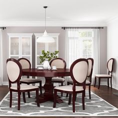 a dining room table and chairs in front of a fireplace