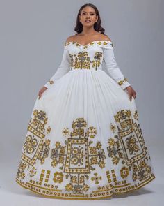 Step into the world of Ethiopian fashion with the mesmerizing beauty of the Habesha Kemis. This traditional attire, adorned with intricate embroidery and crafted from the finest Menen fabric, is a true masterpiece that embodies the rich cultural heritage of Ethiopia. Immerse yourself in the breathtaking artistry of the Habesha Kemis, where every stitch tells a story and every thread weaves a connection to the past. The full embroidery adorning this garment showcases the unparalleled skills of Et Anarkali Floor-length Dress With Embroidered Neckline, Floor-length Dresses With Embroidered Neckline For Festive Occasions, Festive Floor-length Dresses With Embroidered Neckline, Fitted Dresses With Pallu For Traditional Ceremonies, Anarkali Style Long Sleeve Maxi Dress For Traditional Ceremonies, Bohemian Fitted Dress With Pallu, White Long Sleeve Dresses For Traditional Ceremonies, Fitted Bohemian Dresses With Pallu, Festive White Dress With Gold Embroidery