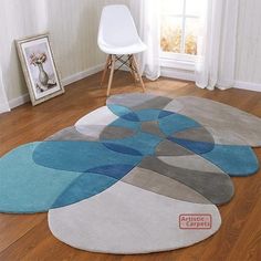 a living room with wooden floors and rugs on the floor in front of a window