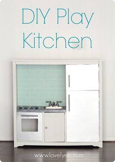 a kitchen with white cabinets and blue tiles on the wall, in front of a green tiled backsplash that says diy play kitchen