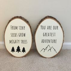 two wood slices with words on them sitting next to each other in front of a wall