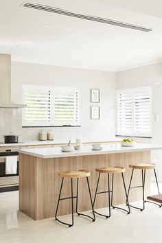 three stools sit in front of a kitchen island