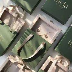 an assortment of green and white boxes with jewelry in them