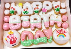 a box filled with lots of decorated doughnuts in the shape of happy birthday