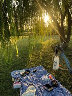 a blue and white blanket sitting on top of a grass covered field next to a bike