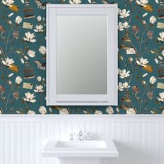 a bathroom sink sitting under a mirror in front of a wall mounted vanity with flowers on it