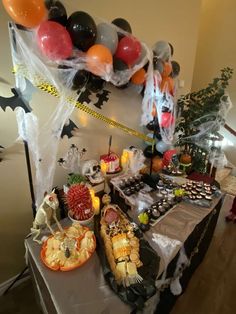 a table topped with lots of food and balloons