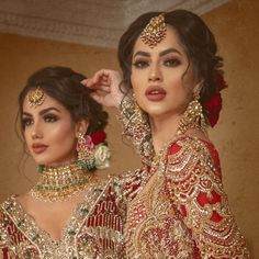 two women dressed in red and gold outfits