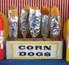 corn dogs are wrapped in tin foil and ready to be served at a carnival party