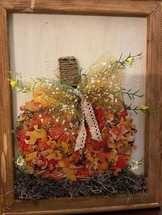 a wooden frame with an autumn decoration in it