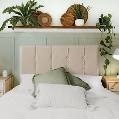 a bed with two plants on top of it and a shelf above the headboard