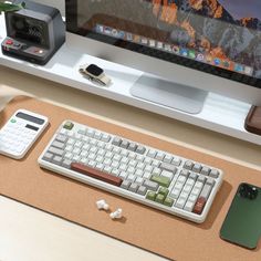 a computer keyboard sitting on top of a desk next to a cell phone and mouse