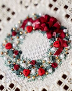 a close up of a piece of cloth with beads and bows on it, in the shape of a wreath