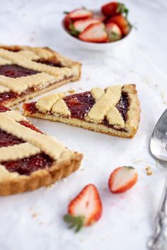 a piece of pie sitting on top of a table next to strawberries and a fork