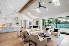 a living room filled with furniture next to a kitchen and an open concept floor plan