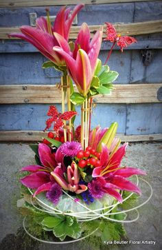 a vase filled with lots of flowers on top of a table