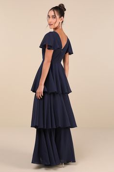 We know that some of your favorite memories will be made while wearing the Lulus Sincerely Exquisite Navy Blue Short Sleeve Tiered Maxi Dress! This timeless dress has an airy woven chiffon composition that shapes a lightly gathered bodice with a surplice neckline and V-back, framed by fluttery short sleeves. The high, fitted waist tops a flowy, tiered A-line skirt that falls to an elegant maxi hem. Hidden back zipper/clasp. Fit: This garment fits true to size. Length: Floor length. Size medium m Blue Georgette Dresses With Ruffles, Tiered Chiffon Evening Dress, Flowy Tiered Chiffon Dress For Evening, Flowy Tiered Chiffon Evening Dress, Flowy Tiered Chiffon Wedding Dress, Blue Ruffled Maxi Chiffon Dress, Flowy Blue Georgette Maxi Dress, Blue Ruffled Maxi Dress For Wedding Guest, Flowy Tiered Evening Dress