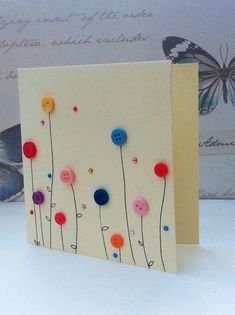 a card with buttons on it sitting next to a butterfly