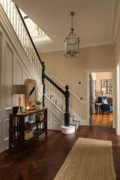 a hallway with stairs, table and lamp