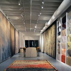 an art gallery with rugs and paintings on the walls