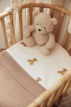 a teddy bear sitting on top of a crib