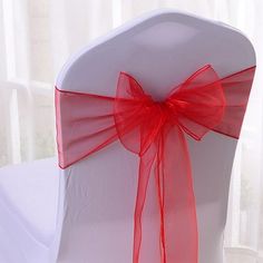 a white chair with red ribbon on it