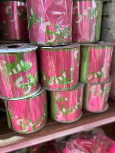 several rolls of pink and green tins on a shelf