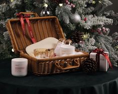 a wicker basket sitting on top of a table next to a christmas tree filled with presents