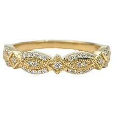 a yellow gold ring with white diamonds on the sides and an intricate design in the middle