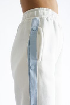 Tearaway pants for workout or wear out. With a relaxed fit and snap down side buttons, wear with our Coat of Arms or Varsity Wellness Sweatshirt. Soft white coloring with baby blue details Tearaway design along legs with button closure Tapered, stretchy waistline with secure front pockets Soft, fuzzy interior Straight leg ankle These pants are made from 100% recycled fabric — 52% cotton, 48% polyester Measurements on size S: waist 25 inches, inseam 28.5 inches Your order will ship from our wareh Men Stylish Dress, Fleece Pants, Sport Fashion, Off Shoulder Blouse, Baby Blue, Set Dress, Straight Leg, Relaxed Fit, Mens Outfits