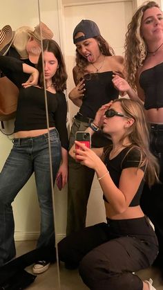 a group of young women standing next to each other in front of a bathroom mirror