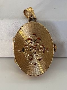 This hand-made oval locket is as sentimental and unique as it gets. It is a perfect Christmas or Hanukah. It is made of 14 karat gold. It is both beautiful and functional. Most lockets can hold 2 pictures but this one can hold 4 special photos close to your, or your loved one's heart! The photos are easy to slip through slots at top of locket. It is hard to match the workmanship of this locket and it's engraving. It was crafted by a very talented jeweler in the NYC jewelry district between 1970 - 1980. Lockets are his legacy and his remaining inventory is being sold on this site. Most are one of a kind and will not be available after it is sold. The best jewelers are in awe of the workmanship and you will always get compliments. This precious locket and can easily become a heirloom that ca Heirloom Oval Engraved Locket Necklace, Elegant 14k Gold Oval Locket Necklace, Elegant Oval 14k Gold Locket Necklace, Elegant Rose Gold Oval Locket Necklace, Yellow Gold Round Filigree Locket Necklace, Yellow Gold Round Locket Necklace With Filigree, Round Yellow Gold Locket Necklace With Filigree, Heirloom Yellow Gold Oval Pendant Locket Necklace, Engraved Yellow Gold Oval Locket Necklace