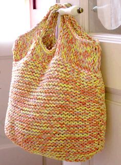 an orange and yellow bag hanging on the side of a white door with a mirror behind it