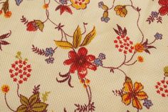 the fabric has flowers on it and is white with red, yellow and blue colors