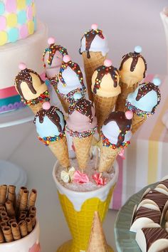 ice cream cones with chocolate and sprinkles are in a cup on a table