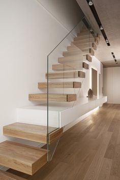 a wooden staircase with glass balconies and wood treads in an empty room