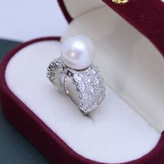 Looking for a timeless piece of pearl jewelry to add to your collection? House of Pearls’ 12-13mm Freshwater Pearl & Large Full CZ Wide Diamond Ring is the perfect classic addition. This ring offers a large 12-13mm freshwater pearl alongside a large full CZ diamond, making it wearable luxury. Celebrate your special moments by wearing this beautiful pearl & diamond ring. White 12-13mm Freshwater Pearl Ring This popular ring design features AAAA quality, round freshwater pearls measuring 12-13mm. Luxury Akoya Pearl Ring In Diamond White, Luxury Diamond White Akoya Pearl Ring, Luxury Akoya Pearl Ring With Pearl Drop, Luxury Akoya Pearl Ring In Pearl White, Luxury Pearl White Round Pearl Ring, Fine Jewelry White Gold Pearl Ring, White Gold Pearl Ring In Fine Jewelry Style, Luxury Round Pearl White Ring, White Gold Pearl Ring With Pearl Drop