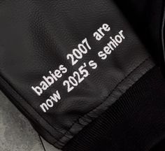 the back of a black leather jacket with white lettering that says babies are now 2055