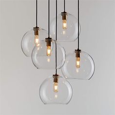 four clear glass globe pendant lights hanging from a ceiling