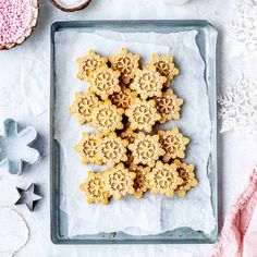 some cookies are on a tray next to cupcakes