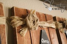 three pieces of wood are tied together with rope and twine to make a wall decoration